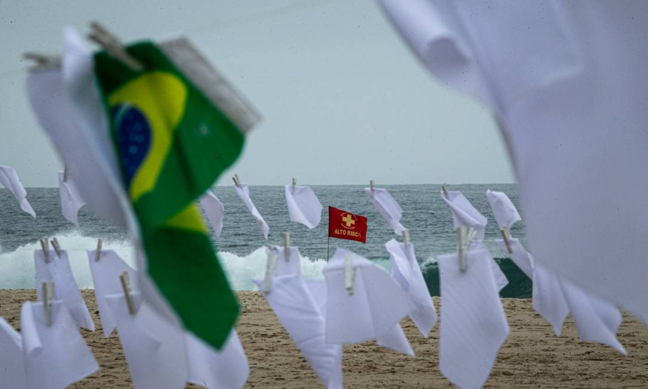 Alto risco. Bandeira de alerta de segurança para mergulho no mar é visto entre lenços brancos e a bandeira nacional em ato da ONG Rio de Paz Foto: Hermes de Paula / Agência O Globo