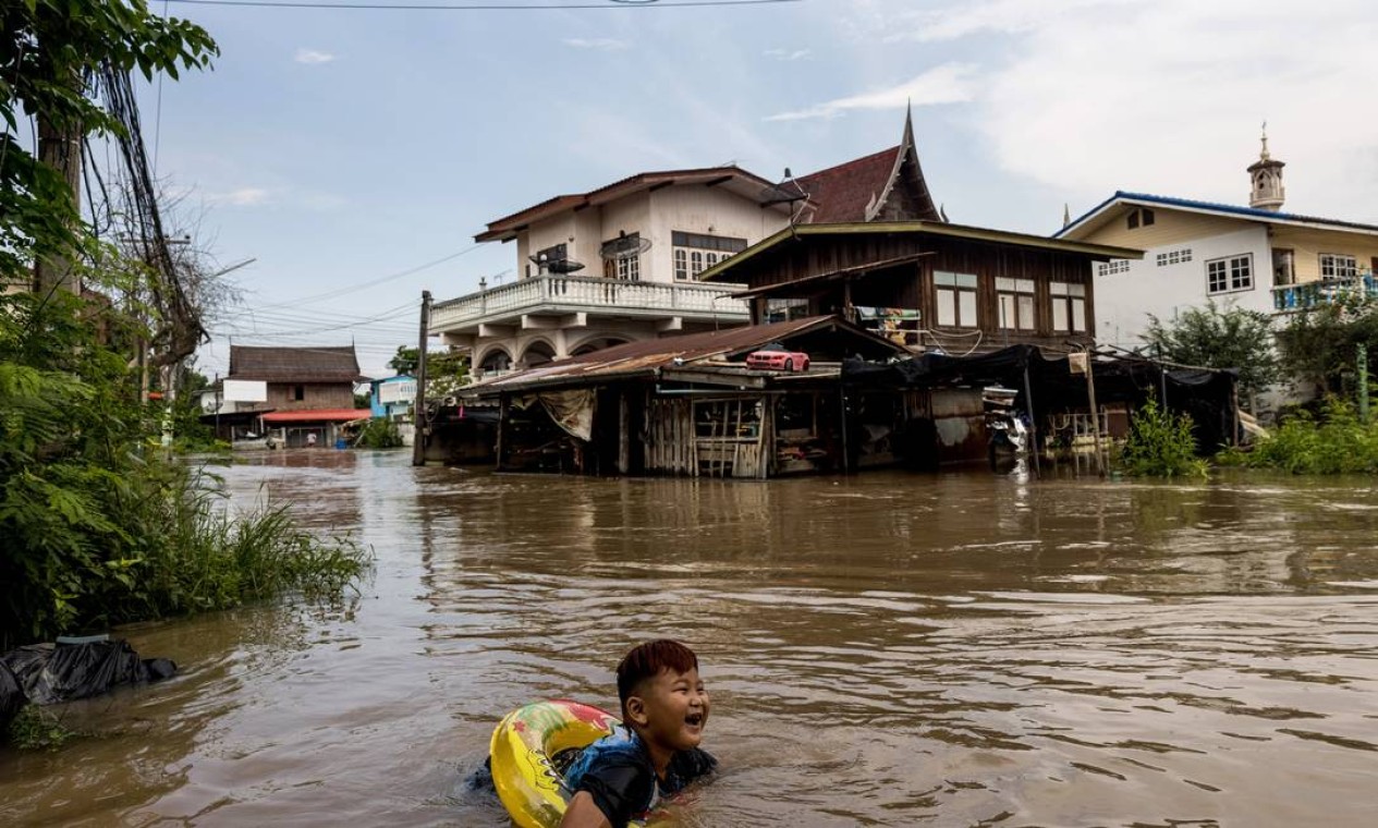 Menino nada em rua alagada de um bairro de Ayutthaya, depois que a tempestade tropical Dianmu causou inundações em 31 províncias do da Tailândia Foto: JACK TAYLOR / AFP