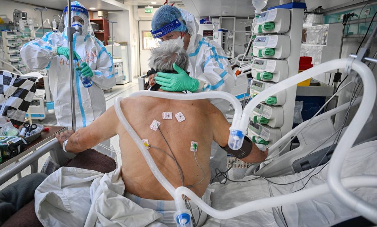 Equipe médica atende um paciente com covid-19 em UTI de hospital em Bucareste, na Romênia Foto: DANIEL MIHAILESCU / AFP