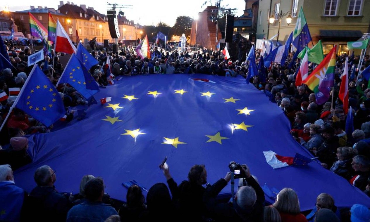 Manifestantes seguram bandeira da União Europeia durante ato em Varsóvia, em apoio à adesão do país ao bloco, depois da uma decisão histórica da Justiça local agravar crise e aumentar preocupação de que a Polônia possa deixar a UE. Foto: WOJTEK RADWANSKI / AFP