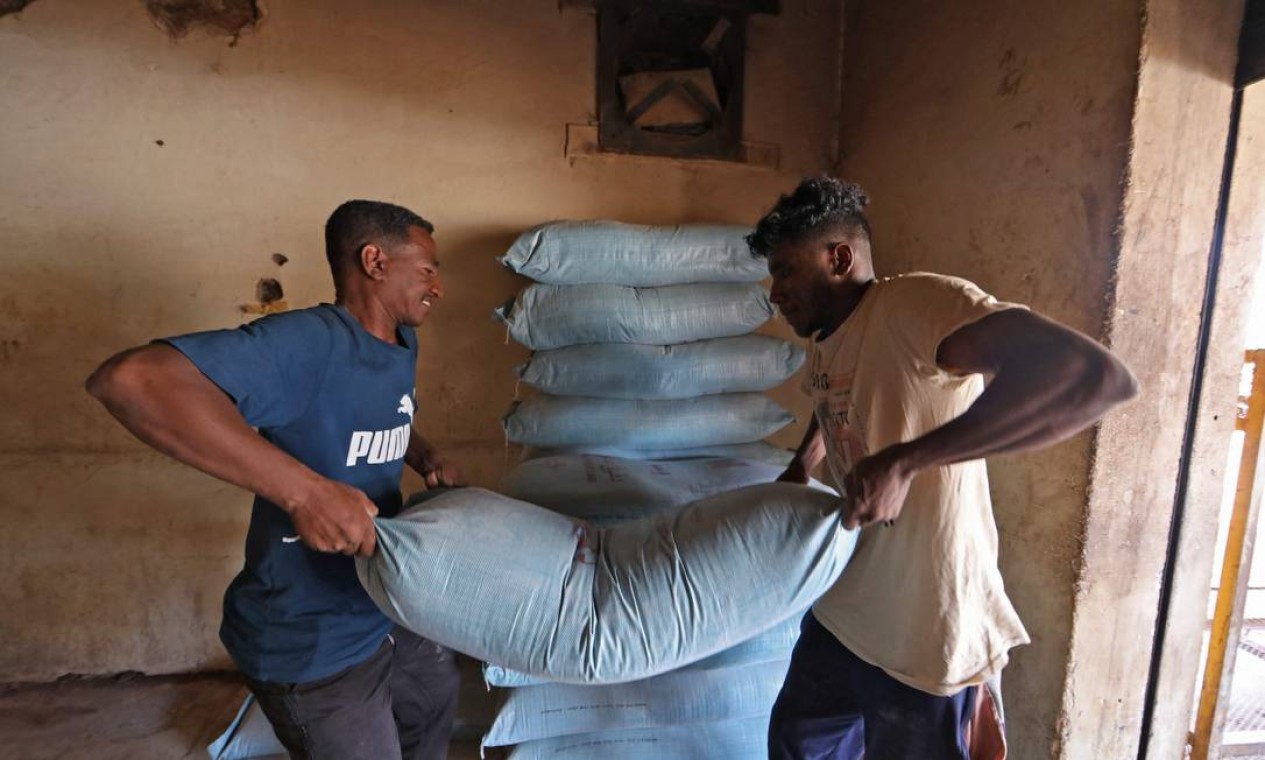 Trabalhadores empilham sacos de farinha em uma padaria na capital, Cartum, enquanto o Sudão sofre com a escassez de trigo e outras commodities essenciais devido ao fechamento de Porto Sudão em meio a protestos Foto: MUJAHED SHARAF AL-DEEN SATI / AFP