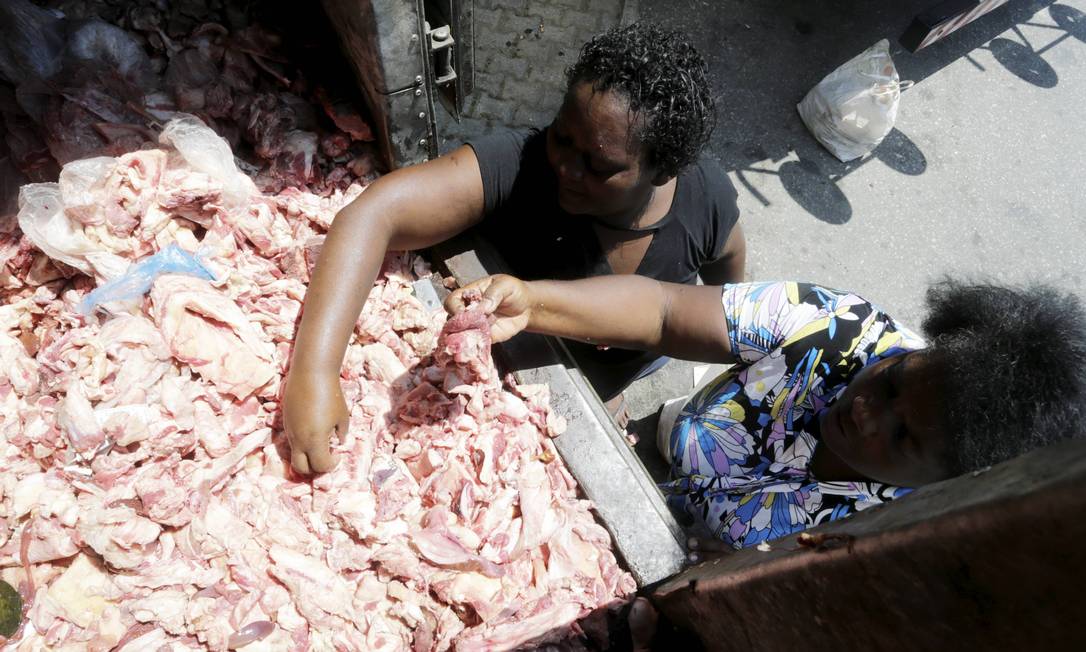 Mulheres pegam osssos e pelancas para alimentar a família no Catete, no Rio de Janeiro Foto: Domingos Peixoto / Agência O Globo