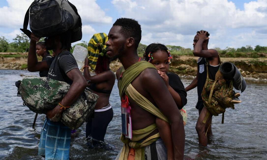 Haitianos cruzam o rio Chucunaque após caminharem por cinco dias pelo Tampão de Darién Foto: LUIS ACOSTA / AFP/10-2-21
