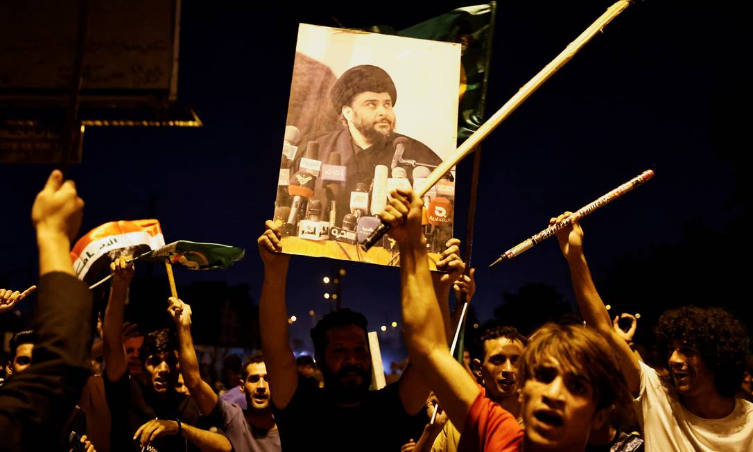 Homem segura foto do clérigo Moqtada al-Sadr durante celebrações após eleições legislativas no Iraque Foto: THAIER AL-SUDANI / REUTERS