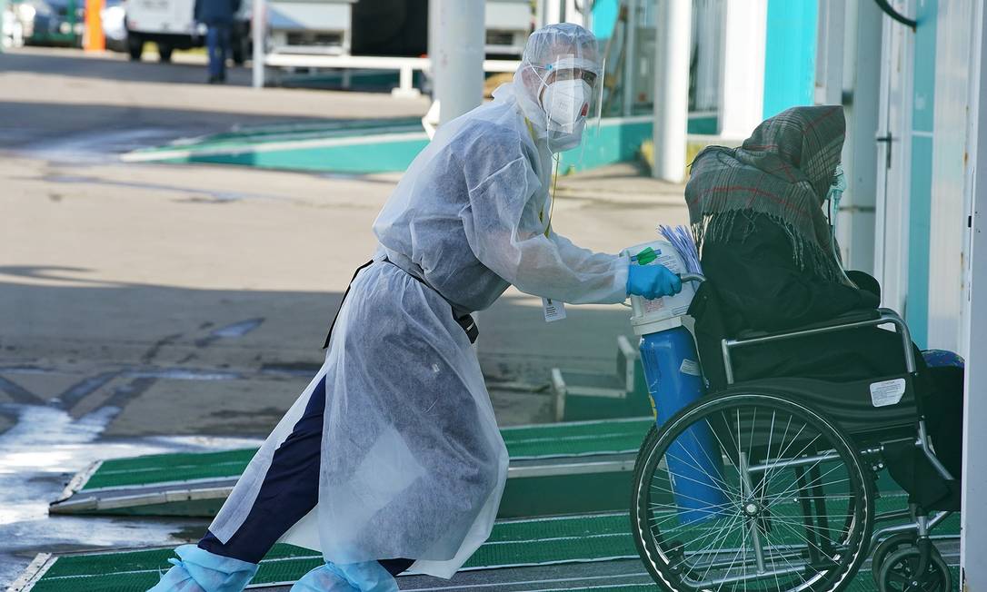 Trabalhador da saúde tranposrta paciente infectado com Covid-19 em Moscou, na Rússia Foto: TATYANA MAKEYEVA / REUTERS