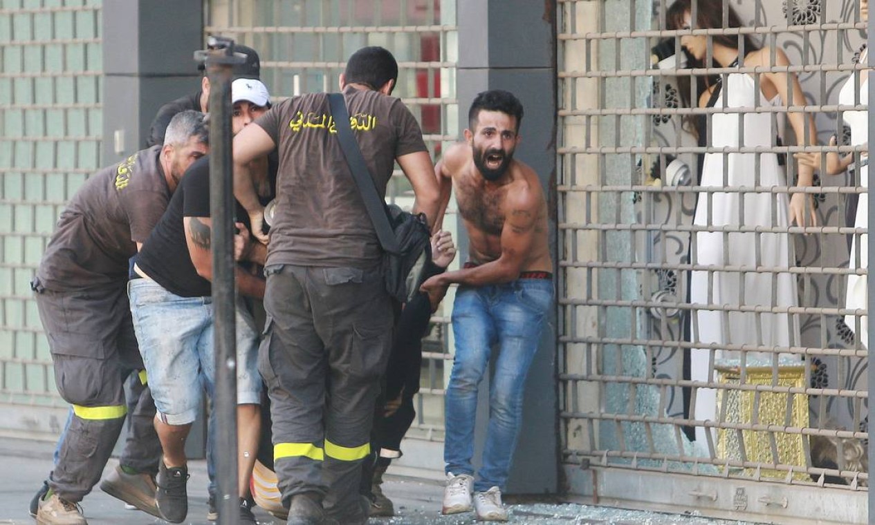 Civis socorrem pessoa ferida em tiroteio Foto: AZIZ TAHER / REUTERS