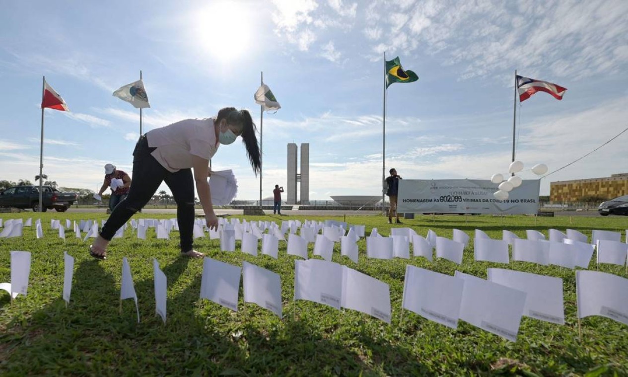 Integrantes da Associação de Vítimas e Familiares da COVID-19 (AVICO) colocam 600 bandeiras brancas em frente ao Congresso Nacional, em Brasília Foto: Evaristo Sá / AFP