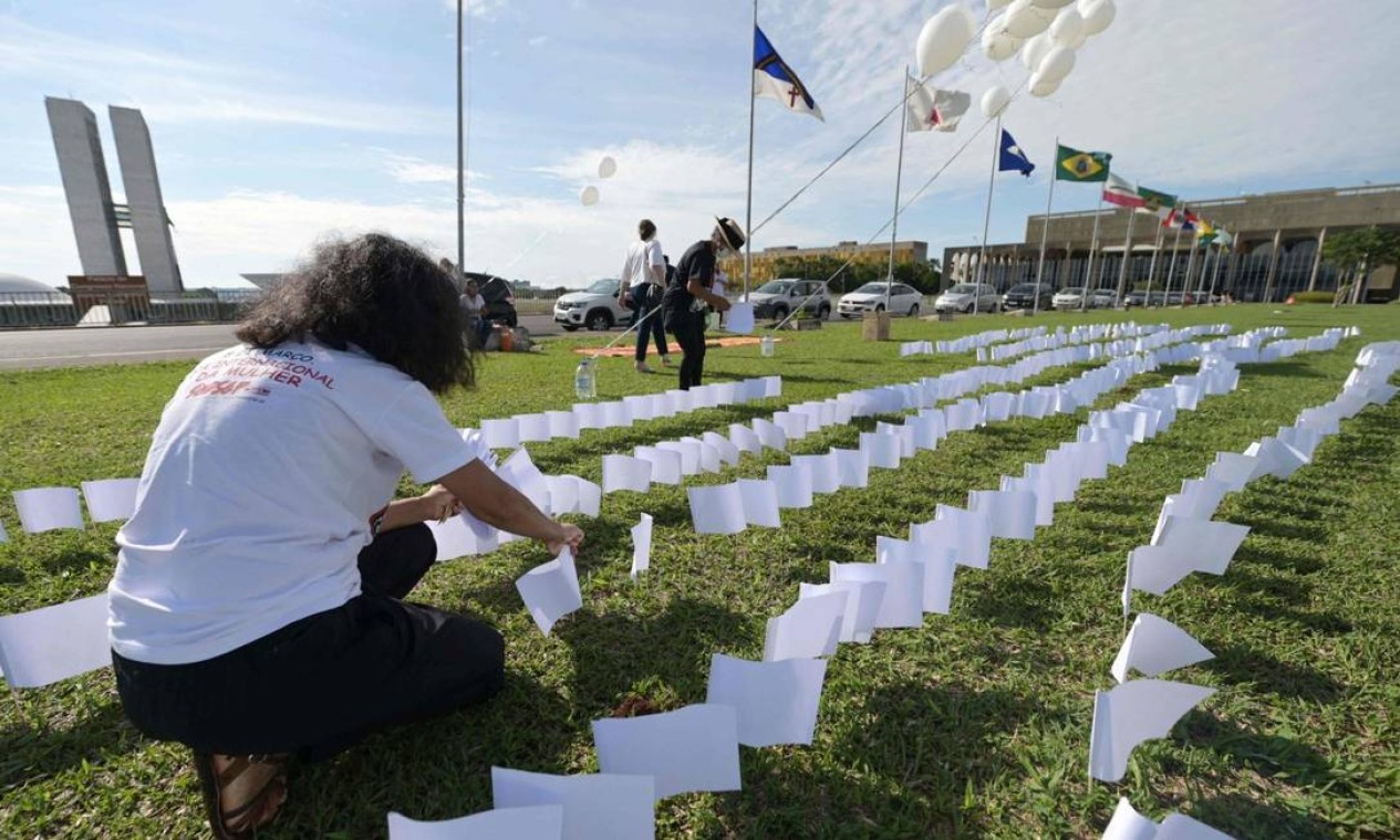 Integrantes da Associação de Vítimas e Familiares da COVID-19 (AVICO) colocam 600 bandeiras brancas em frente ao Congresso Nacional, em Brasília Foto: Evaristo Sá / AFP