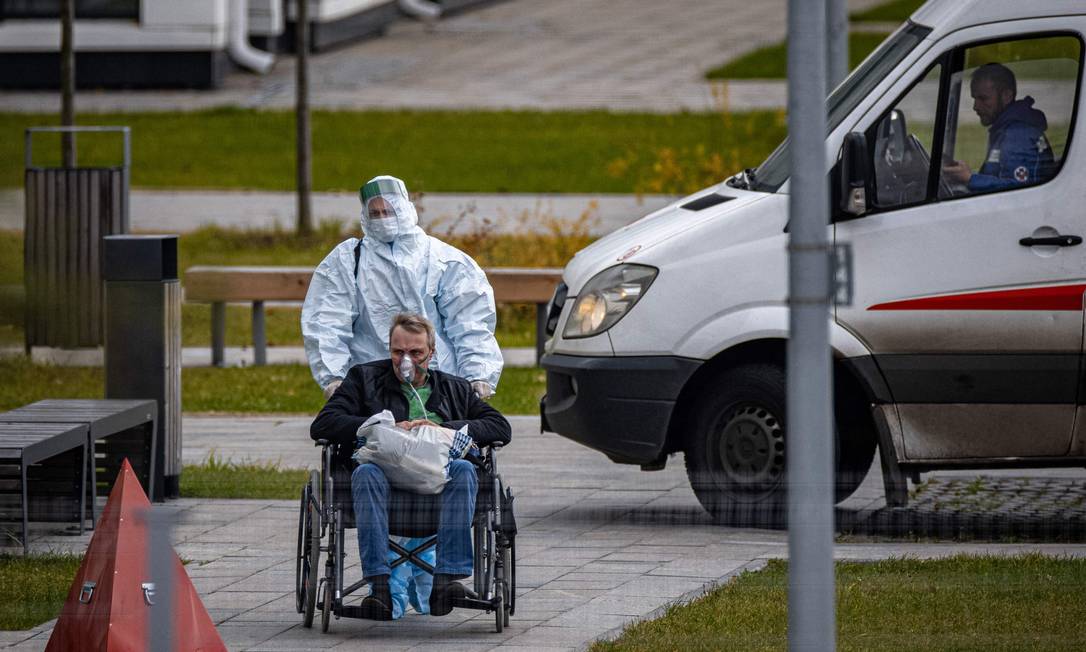 Profissional da saúde empurra paciente de Covid-19 em hospital de Moscou, na Rússia Foto: DIMITAR DILKOFF / AFP