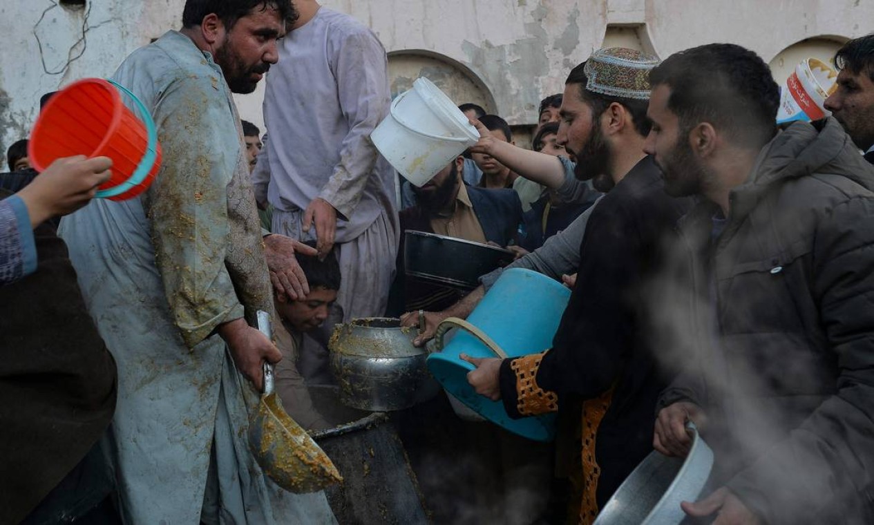Povo afegão distribui comida por ocasião do Eid-e-Milad-un-Nabi, que marca o aniversário de nascimento do Profeta Maomé, na cidade de Herat Foto: HOSHANG HASHIMI / AFP