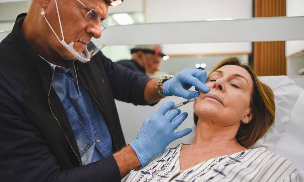 Na foto, Claudio faz preenchimento no chamado 'bigode chinês' em sua clínica Foto: Reprodução