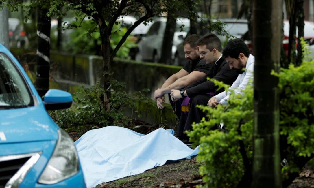 Médico Cláudio Marsili é assassinado a tiros na Barra. Seu filho, o também médico Ítalo Marsili (à esquerda), reza perto do corpo do pai Foto: Gabriel de Paiva/ Agência O Globo