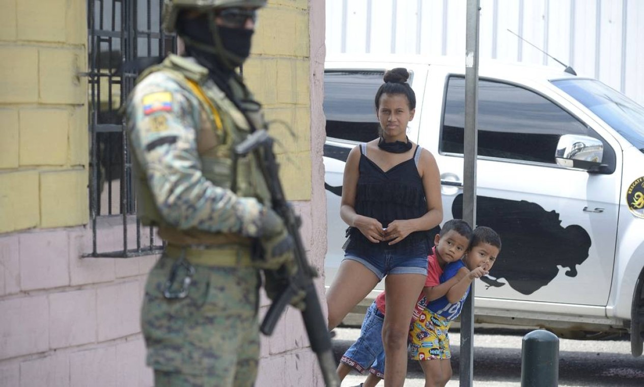 Moradores observam fuzileiros navais realizando operações de segurança no sul de Guayaquil, Equador. O presidente, Guillermo Lasso, declarou estado de emergência no país devido ao aumento da violência Foto: FERNANDO MENDEZ / AFP