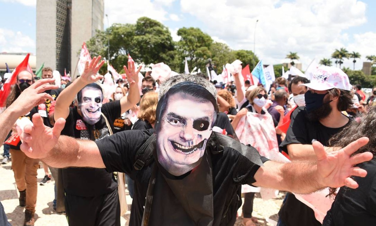 Manifestantes de movimentos sociais usando máscaras retratando o presidente Jair Bolsonaro protestam contra políticas governamentais em frente ao Palácio do Planalto, em Brasília Foto: EVARISTO SA / AFP