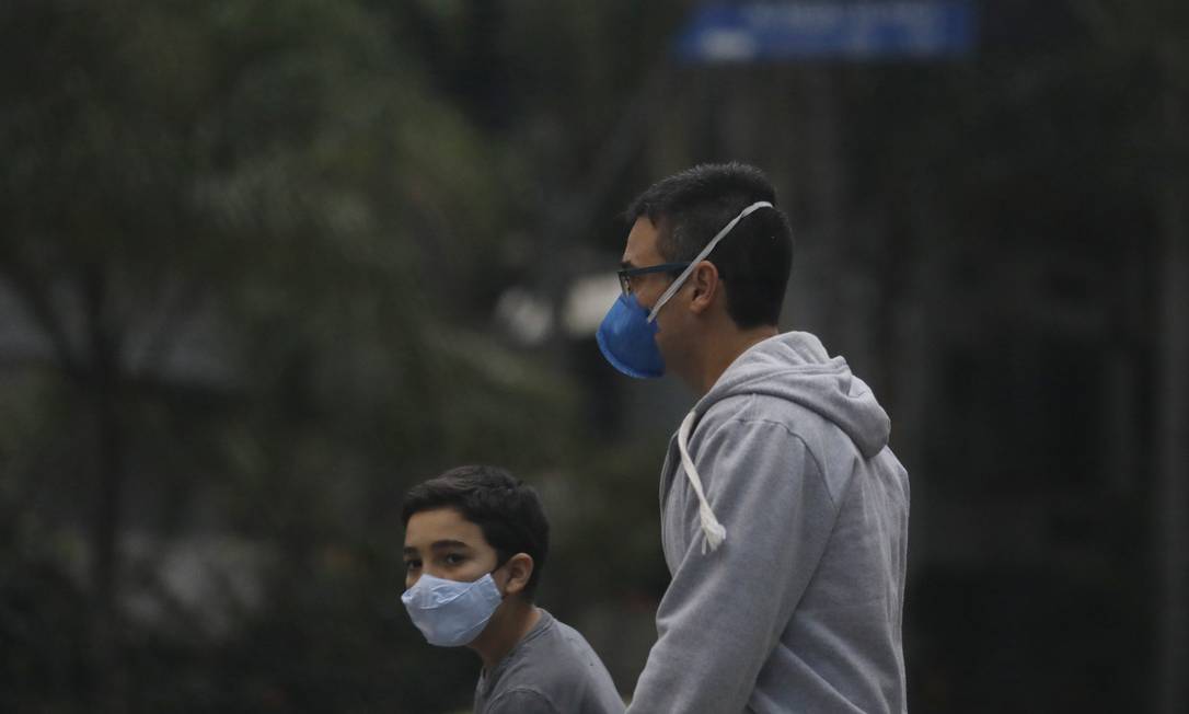 Prevenção: jovens caminham de máscara pelas ruas da cidade Foto: Luiza Moraes / Agência O Globo
