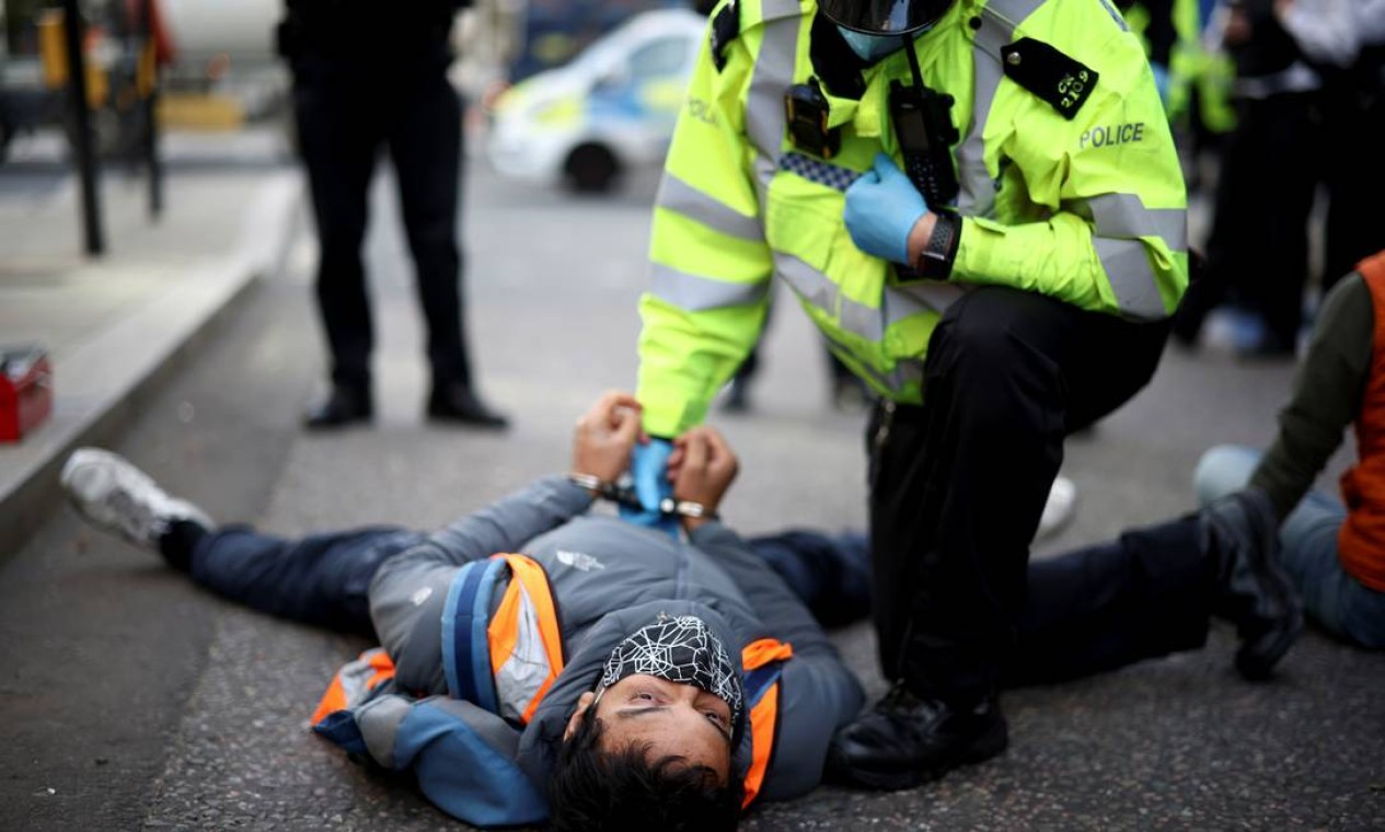 Policial detém um ativista ambiental do Insulate Britain durante um protesto em Londres Foto: HENRY NICHOLLS / REUTERS