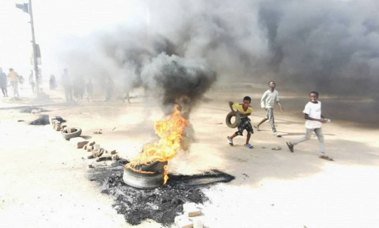 Crianças sudanesas queimam pneus para bloquear uma estrada em Cartum Foto: AFP