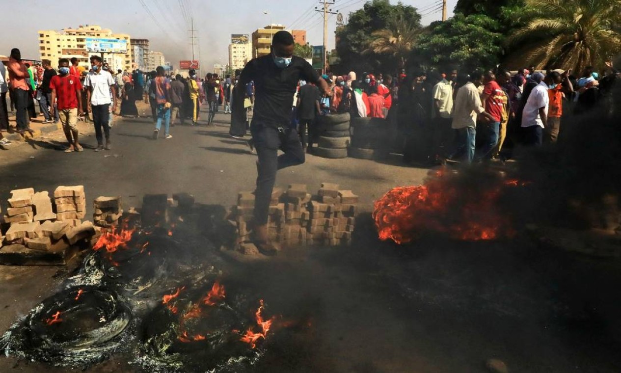 Manifestantes ateiam fogo a pneus em rua de Cartum, capital do Sudão. Militares e civis dividiam o poder desde a derrubada de Omar al-Bashir, em 2019 Foto: AFP
