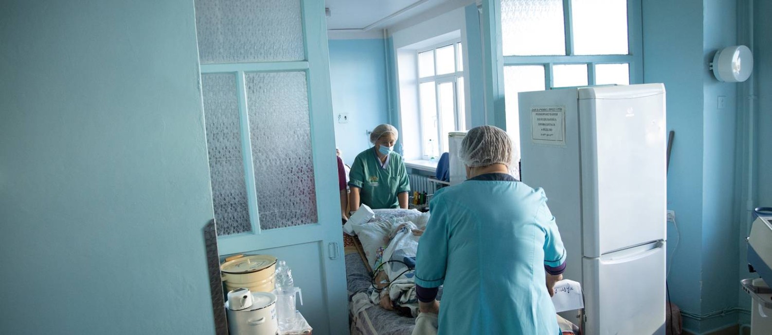 Médicos transportam paciente de Covid-19 em hospital de Kiev, na Ucrânia Foto: STANISLAV KOZLIUK / REUTERS