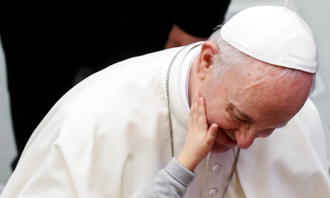 Uma criança toca o rosto do Papa Francisco após a audiência geral semanal no Vaticano Foto: YARA NARDI / REUTERS