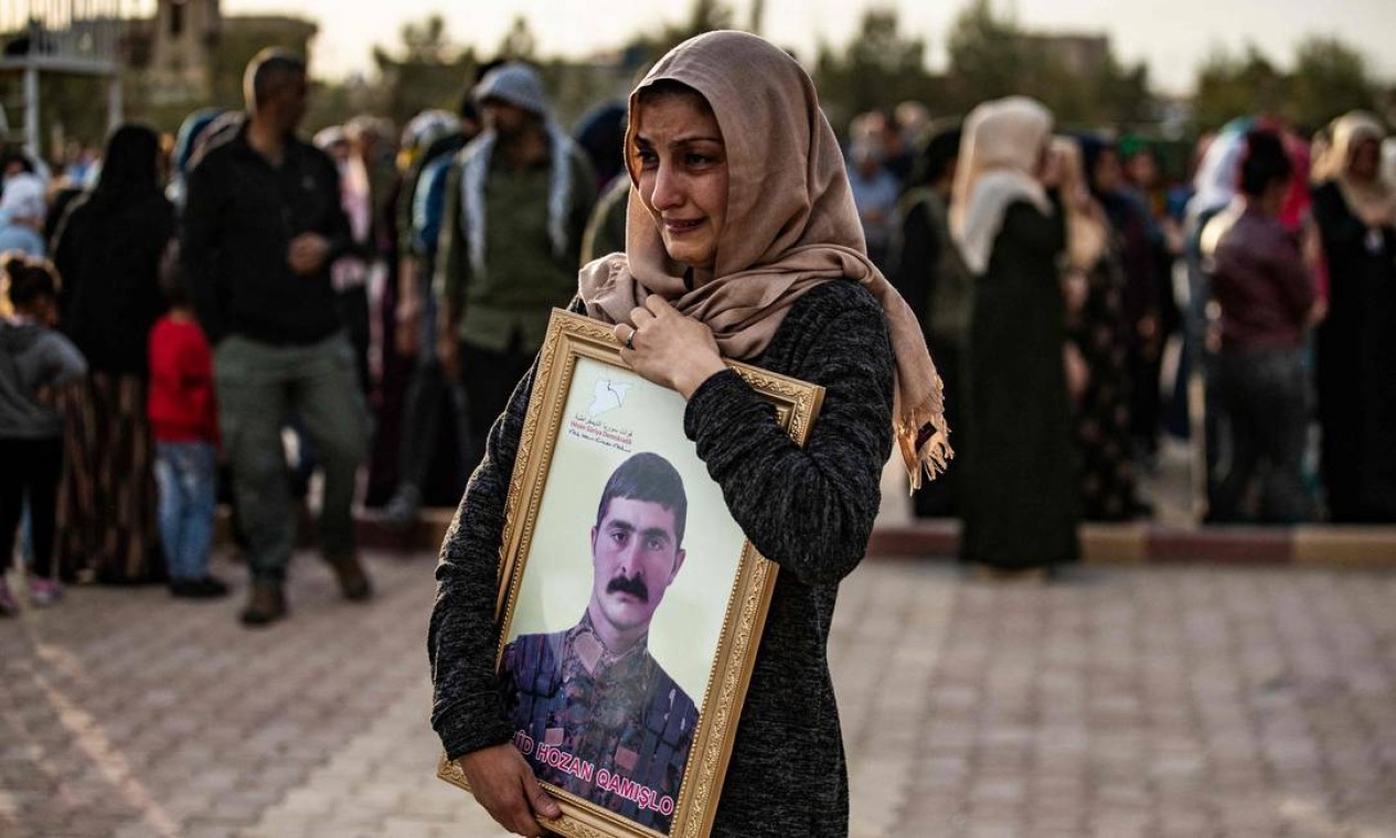 Parentes choram durante o funeral de um membro das Forças Democráticas Sírias (SDF), principalmente curdas, na cidade de maioria curda síria, Qamishli Foto: DELIL SOULEIMAN / AFP