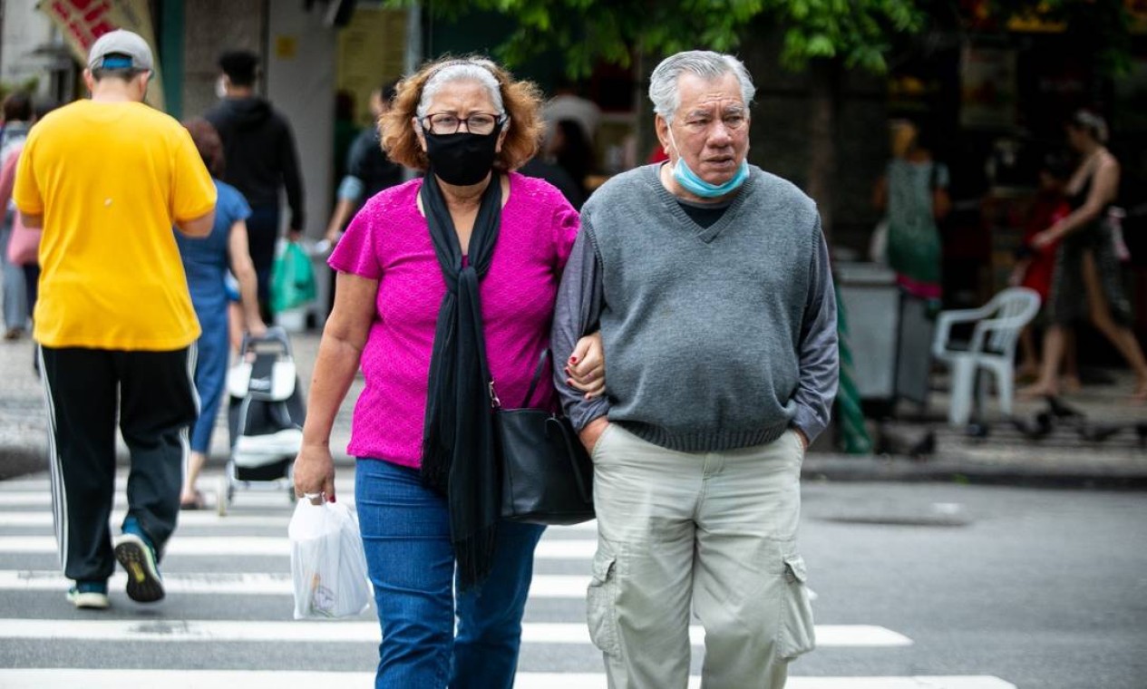 Casal de idosos usa máscara, mas o homem faz o mal uso do acessório Foto: Brenno Carvalho / Agência O Globo