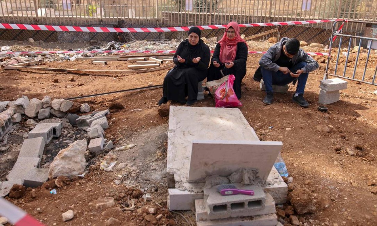 Palestinos visitam o túmulo de um parente em Jerusalém Oriental, onde vários túmulos foram demolidos para estabelecer um parque nacional Foto: AHMAD GHARABLI / AFP