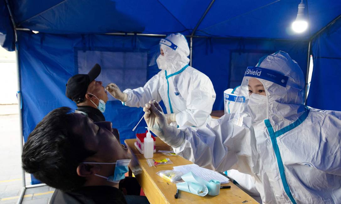Médicos aplicam teste de Covid-19 em moradores da província de Gansu, na China Foto: STR / AFP