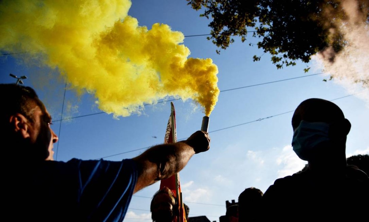 Manifestantes seguram uma bomba de fumaça durante um protesto contra o G-20 Foto: TIZIANA FABI / AFP