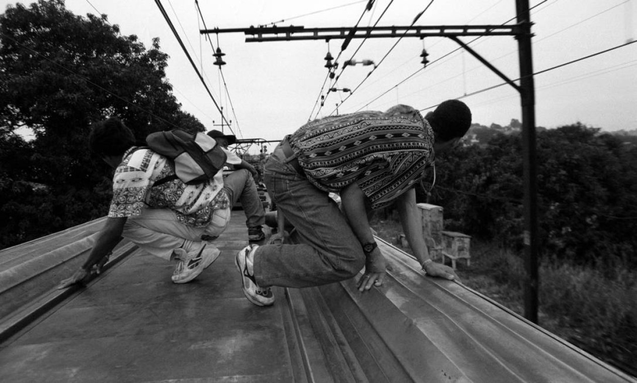 Para registrar os surfistas de trem no ramal da Central do Brasil, em 1994, Custódio subiu na composição pela janela e viajou por três estações no teto do vagão Foto: Custódio Coimbra / Agência O Globo