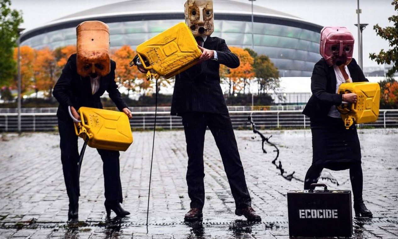 Ativistas despejam óleo falso na frente do local onde a COP-26 será realizada em Glasgow para protestar contra as faltas de ações mais firmes para evitar uma catástrofe climática no mundo Foto: ANDY BUCHANAN / AFP