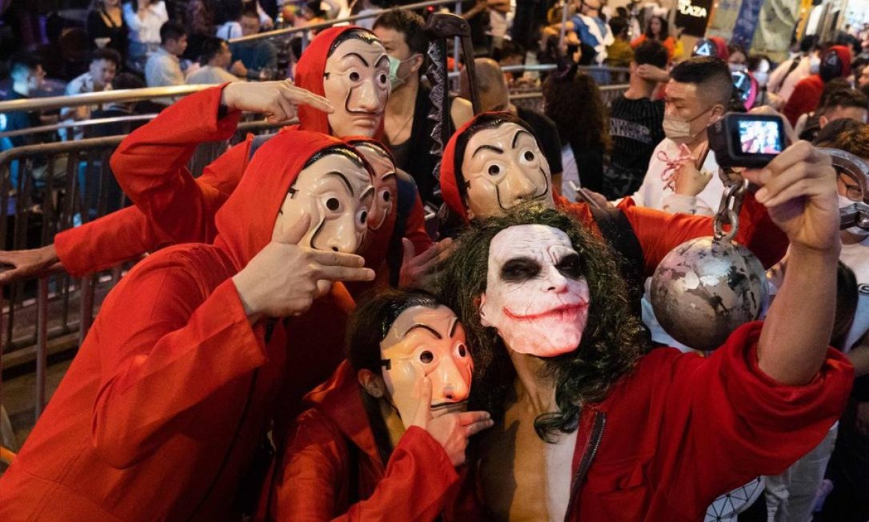 Foliões fantasiados de Coringa e como os assaltantes da série "La Casa de Papel" participam das celebrações do Halloween em Hong Kong Foto: BERTHA WANG / AFP