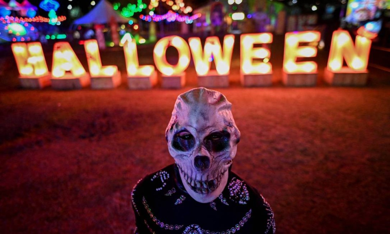 Folião com máscara de esqueleto durante um show no River View Park, em Cali, Colômbia, antes do Halloween Foto: LUIS ROBAYO / AFP