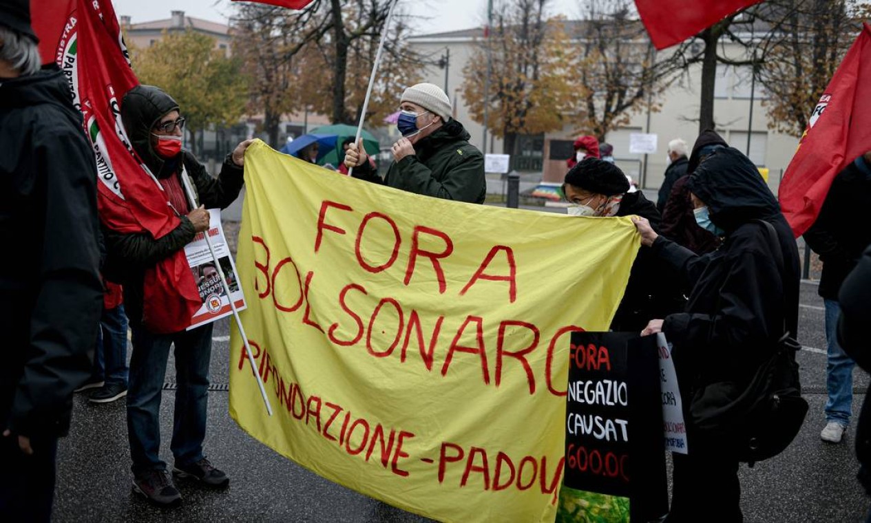 Pessoas seguram "Fora Bolsonaro" durante uma reunião de protesto contra a chegada do presidente brasileiro Jair Bolsonaro em Anguillara Veneta, nordeste da Itália Foto: PIERO CRUCIATTI / AFP