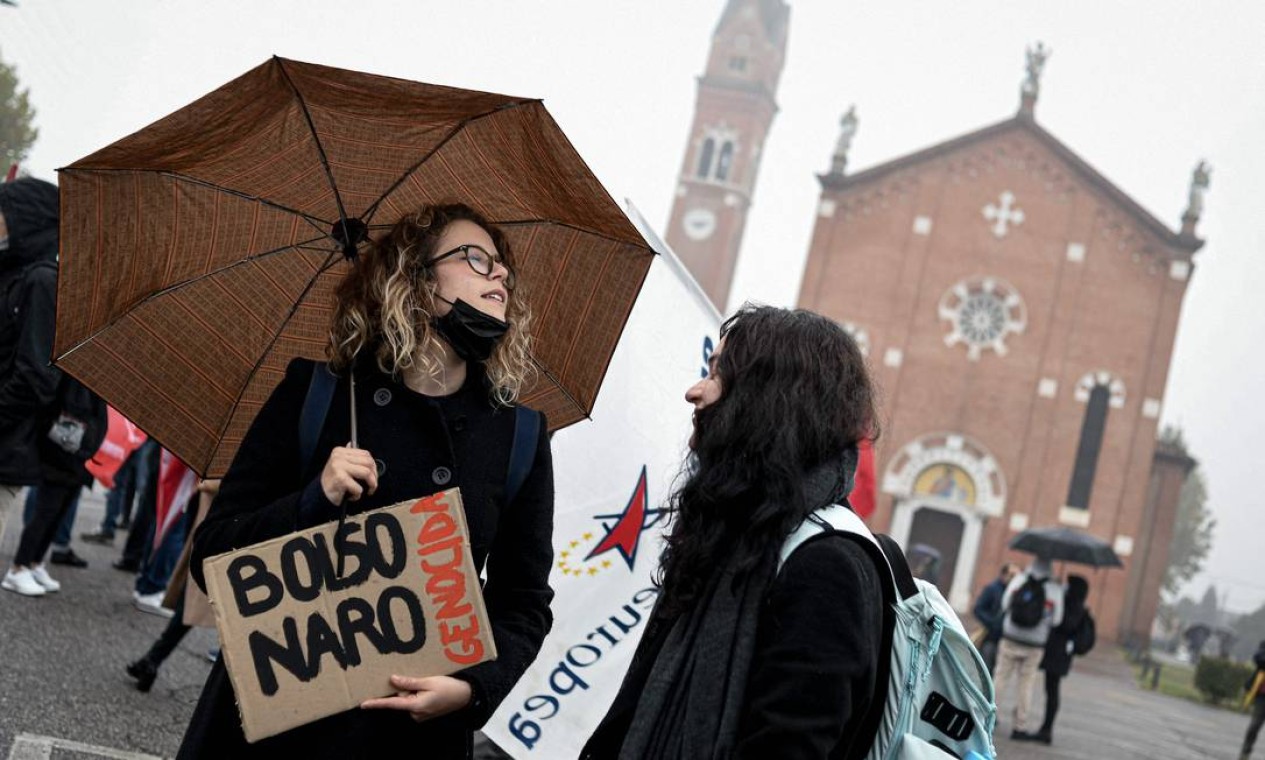 Mulher segura uma faixa com os dizeres "Bolsonaro genocida" durante uma manifestação de protesto contra a chegada do presidente brasileiro Jair em Anguillara Veneta, nordeste da Itália Foto: PIERO CRUCIATTI / AFP