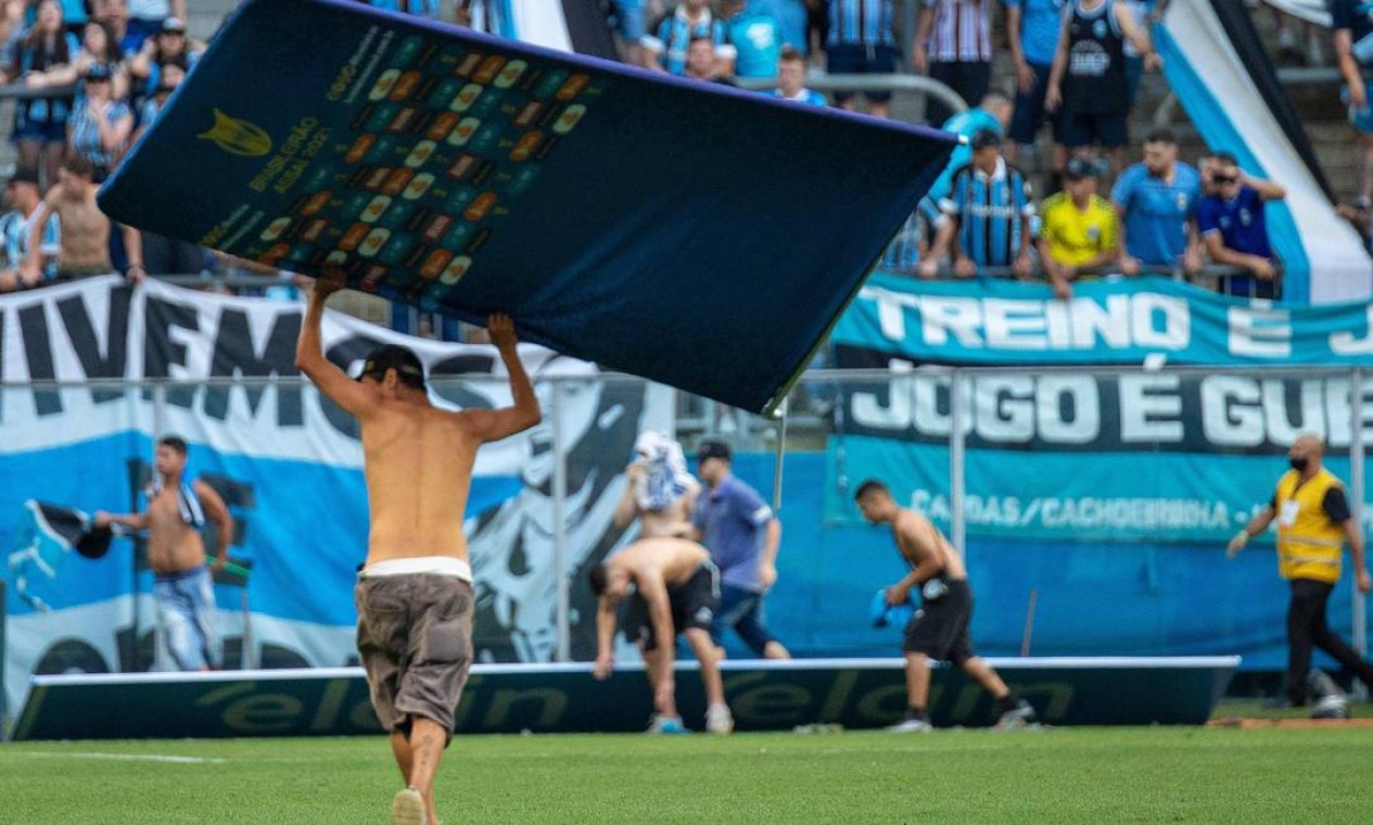 Fans of Gremio invade the pitch at the end of the Brasileirao football match against Palmeiras at the Arena do Gremio stadium in Porto Alegre, Brazil, on October 31, 2021. - Palmeiras won 3-1. (Photo by Raul PEREIRA / AFP) Foto: RAUL PEREIRA / AFP