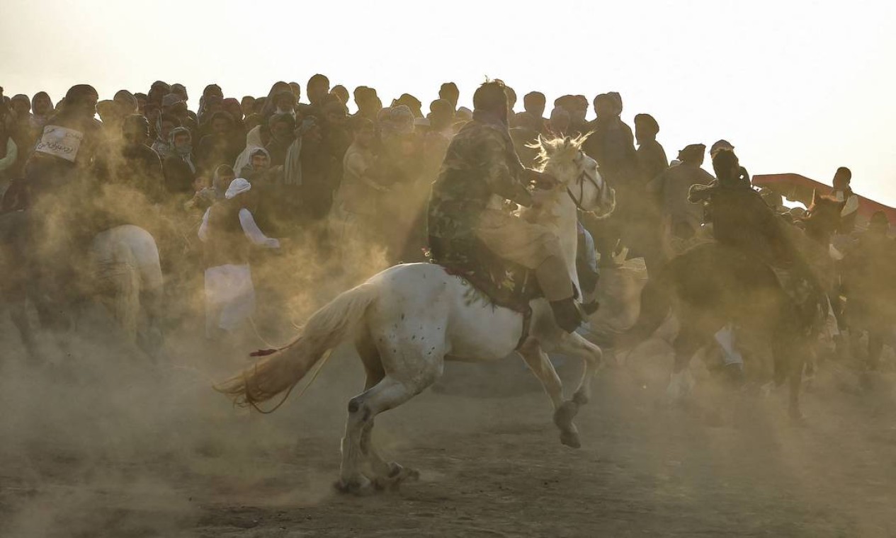 Cavaleiros afegãos competem durante o buzkashi, um esporte da Ásia Central, no qual jogadores montados em cavalos tentam colocar uma carcaça de animal decapitado em um gol. O esporte é jogado na Ásia Central há séculos, com os vizinhos do Afeganistão, Uzbequistão, Tadjiquistão, Turcomenistão, Quirguistão e Cazaquistão, tendo suas próprias variações Foto: WAKIL KOHSAR / AFP