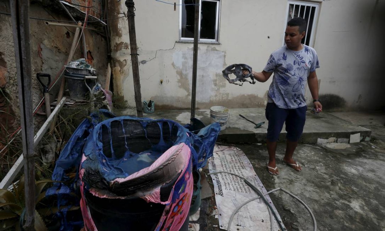 Morador segura pedaço de botijão que explodiu Foto: Fabiano Rocha / Agência O Globo