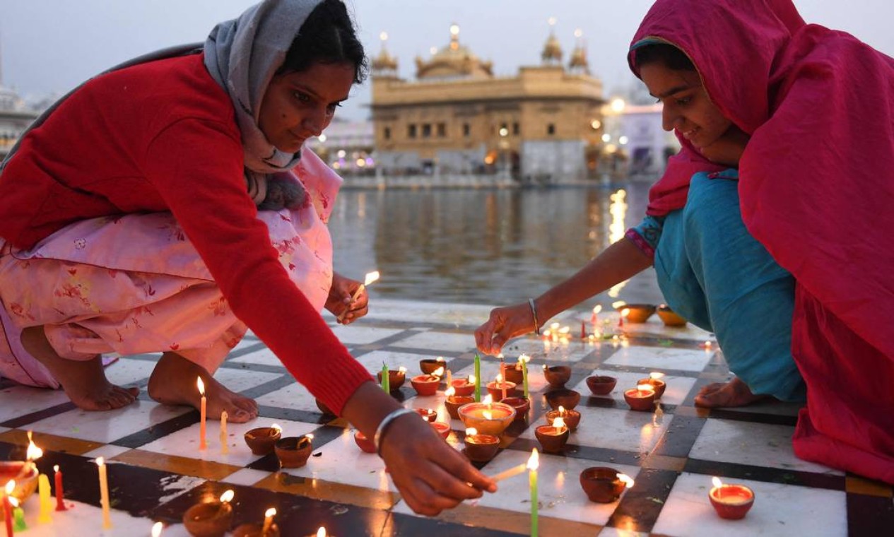 Devotos Sikhs acendem velas por ocasião das "Bandi Chhor Divas" no Templo Dourado iluminado, no início da manhã em Amritsar, Índia Foto: NARINDER NANU / AFP