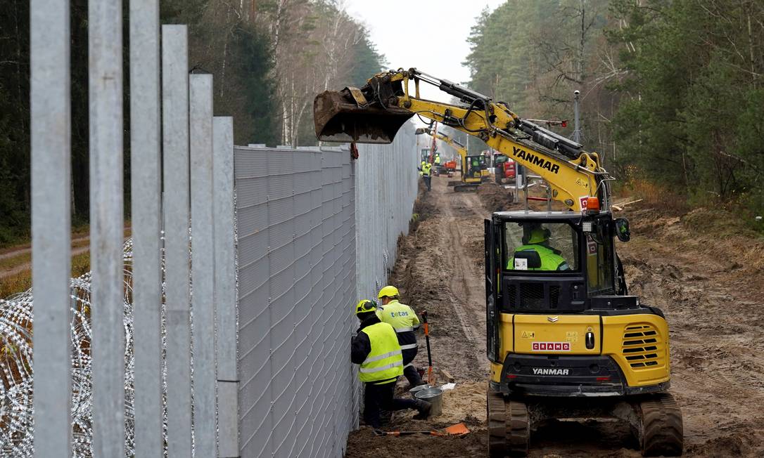 Trabalhadores, como auxílio de maquinário pesado, instalam cerca de metal na fronteira da Lituânia com a Bielorrúsia, em Druskininkai, no dia 4 de novembro de 2021 Foto: JANIS LAIZANS / REUTERS