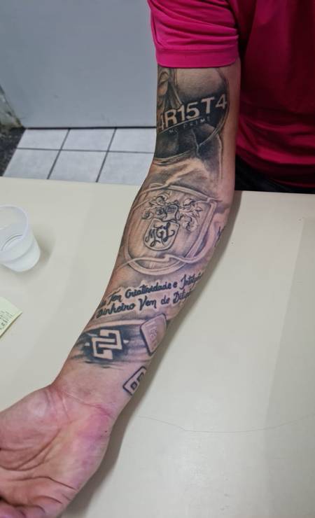Max William Gonçalves Campos, preso por fraude bancária, tem logo de bancos tatuadas em um dos braços Foto: Reprodução