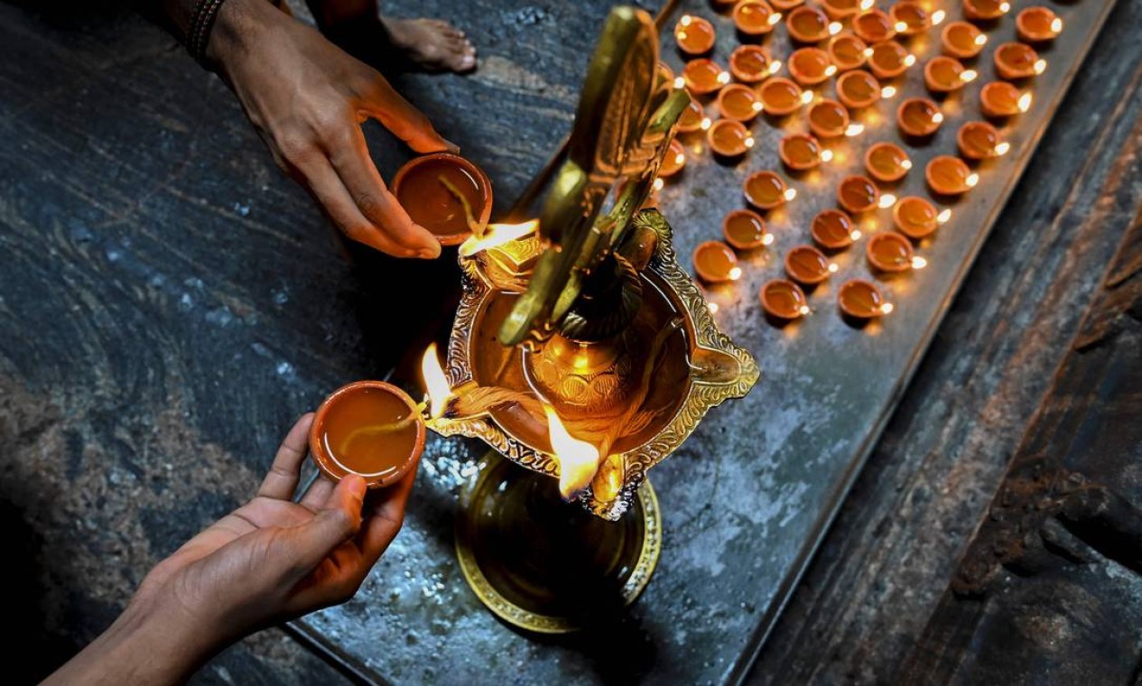 Devotos hindus acendem lâmpadas de óleo enquanto oferecem orações durante Diwali, o festival das luzes, em um templo hindu em Colombo, Sri Lanka Foto: ISHARA S. KODIKARA / AFP