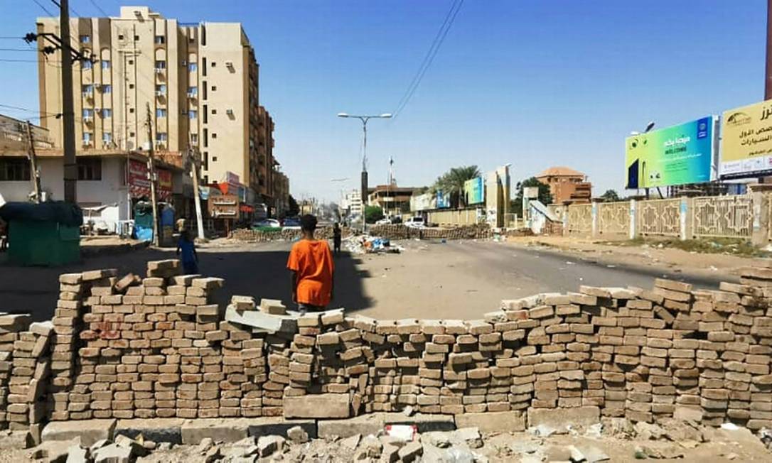 Jovem sudanês em frente a uma barricada feita em rua da capital Cartum durante nova campanha de desobediência civil contra o golpe militar de 25 de outubro Foto: AFP