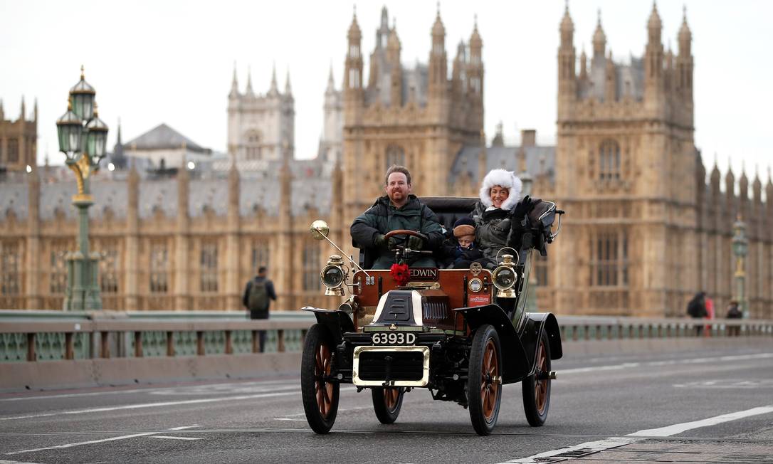Participantes de uma parada de carros antigos na Westminster Bridge, em Londres, com o Parlamento ao fundo Foto: PETER NICHOLLS / REUTERS