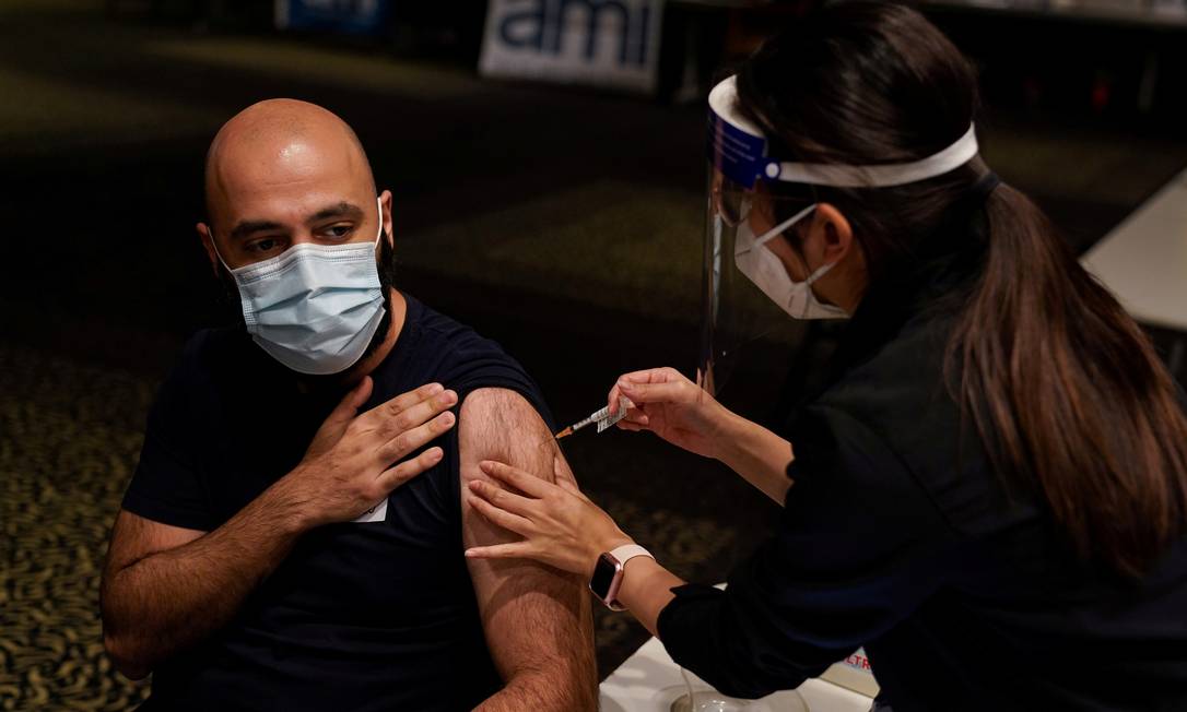 Enfermeira aplica vacina da AstraZeneca contra a Covid-19 em um homem em Sydney, na Austrália. Foto: Loren Elliott / REUTERS