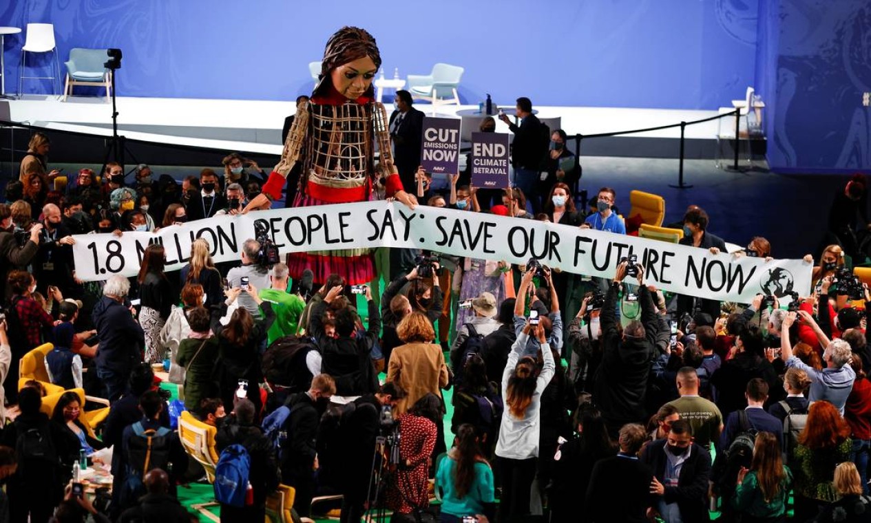 As pessoas se reúnem em torno de "Little Amal", durante a Conferência das Nações Unidas sobre Mudança Climática (COP26) em Glasgow, Escócia Foto: PHIL NOBLE / REUTERS