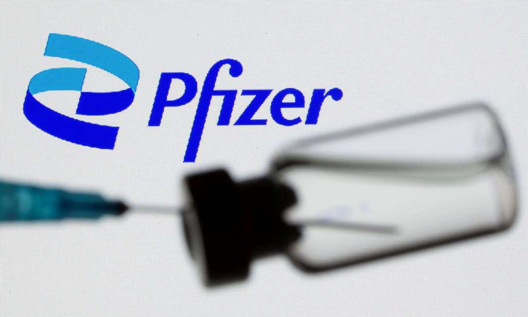 Seringa e um frasco na frente do logotipo da Pfizer Foto: Dado Ruvic / REUTERS