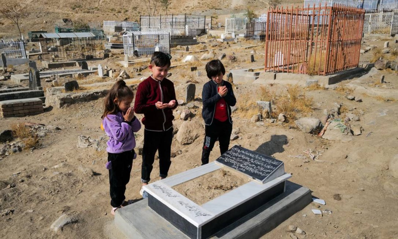 Ada Ahmadi, 7 anos, está ao lado de seus primos enquanto oram perto do túmulo de seu parente Farzad, 12, que foi vítima de um ataque de drone nos EUA que matou 10 civis, incluindo sete crianças, em Cabul, Afeganistão Foto: ZOHRA BENSEMRA / REUTERS