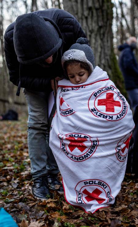 Criança de uma família curda de Dohuk, no Iraque, é coberta por manta da Cruz Vermelha polonesa. Nos últimos três meses, 1.600 pessoas vieram do Curdistão iraquiano para Belarus, graças a um visto de turista, de acordo com a Associação de Refugiados do Curdistão Foto: WOJTEK RADWANSKI / AFP