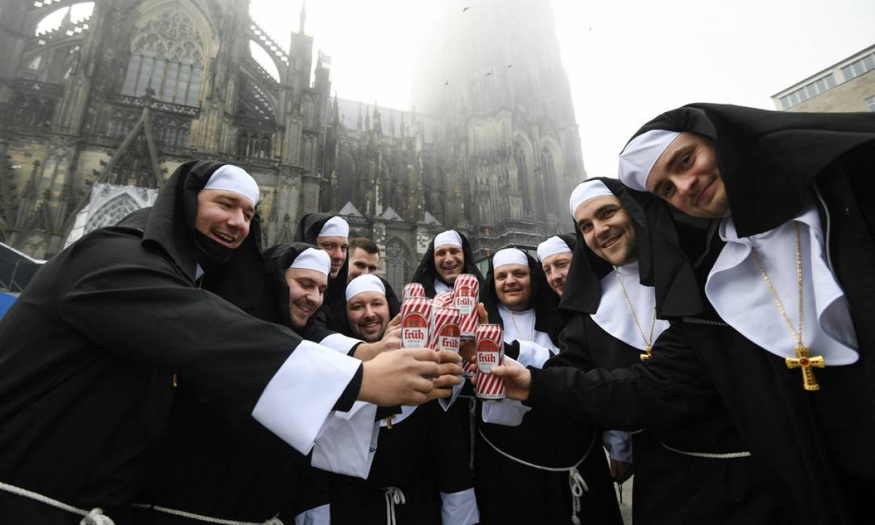 Foliões vestidos de freiras celebram o início da temporada de carnaval na catedral de Colônia, oeste da Alemanha Foto: INA FASSBENDER / AFP